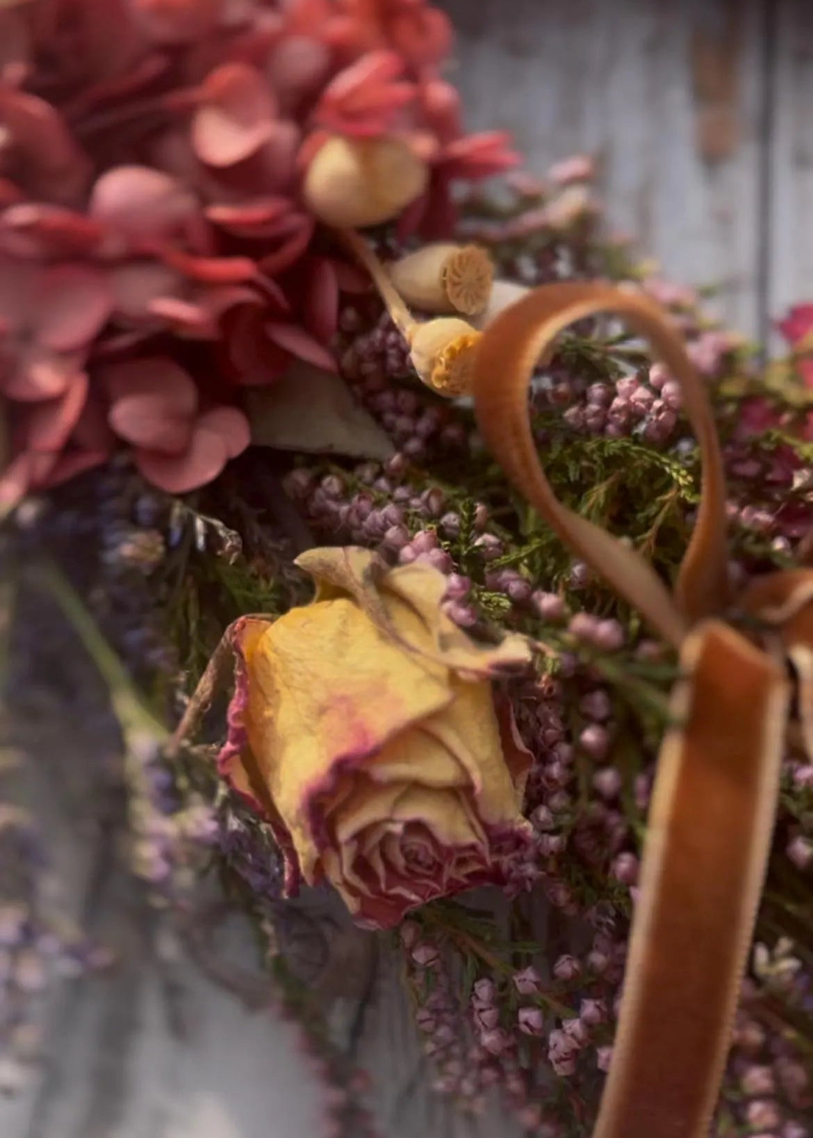 Close-up of a dried flower arrangement with a woven basket.