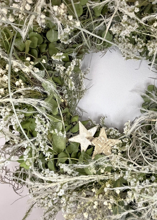 Decorative wreath with stars and greenery on a white background