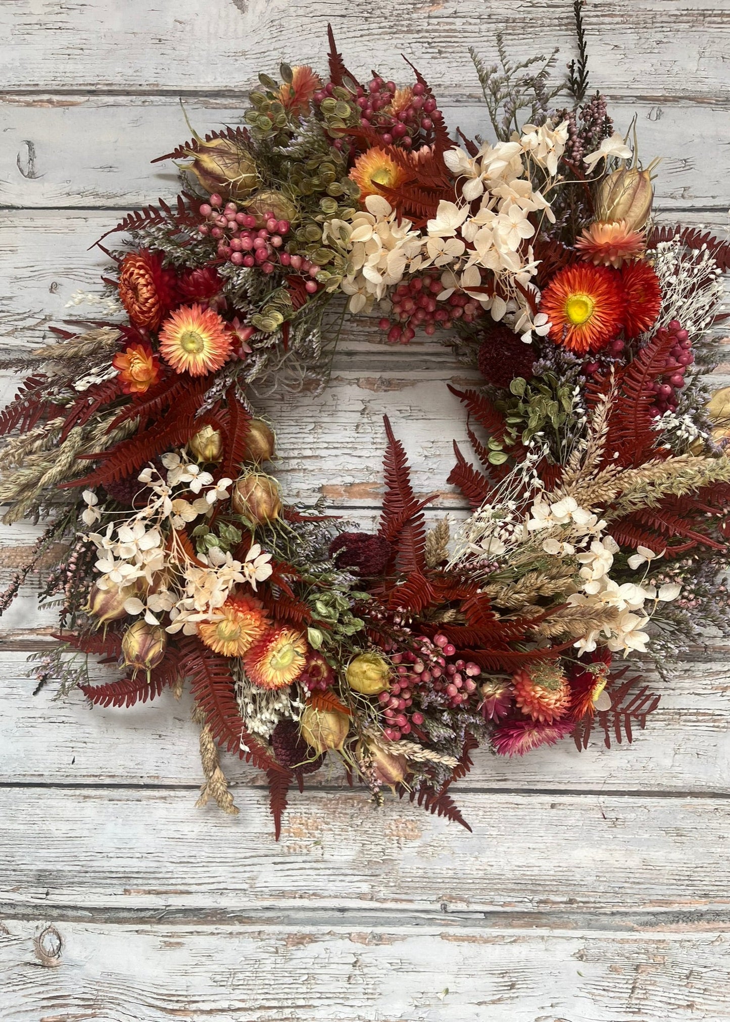 Autumn-themed floral wreath on a wooden background