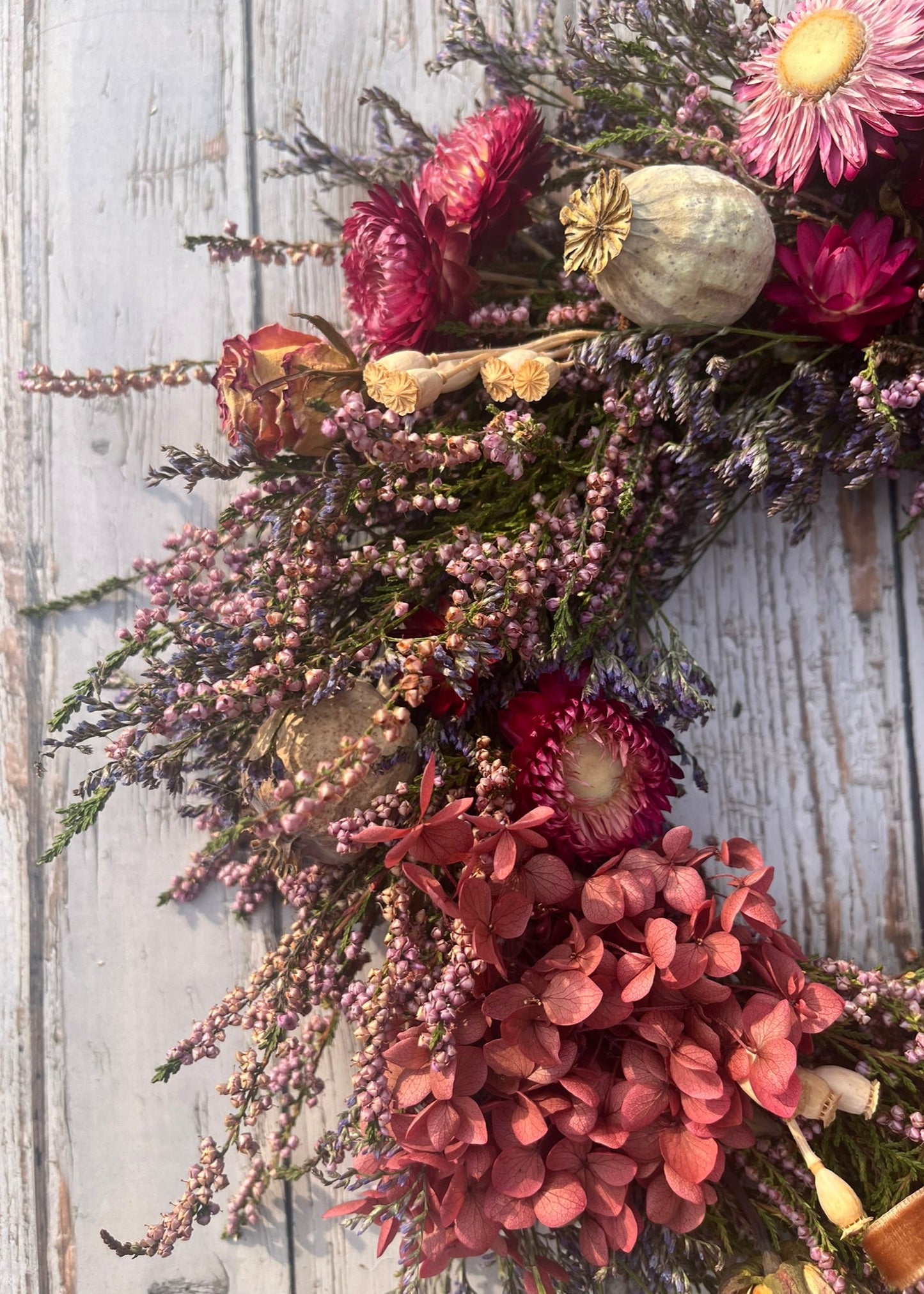 Decorative floral arrangement with pink and purple flowers on a wooden surface