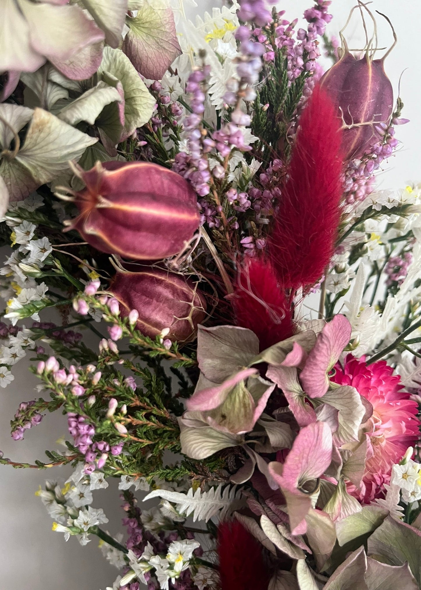 Bouquet of flowers with red feathers against a white background