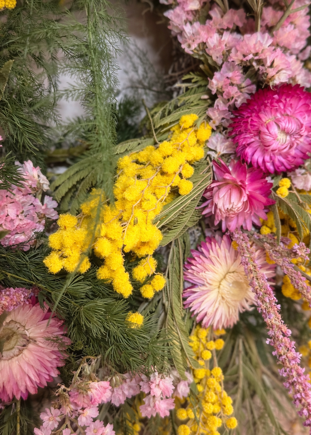 Close-up of a floral arrangement with pink and yellow flowers.