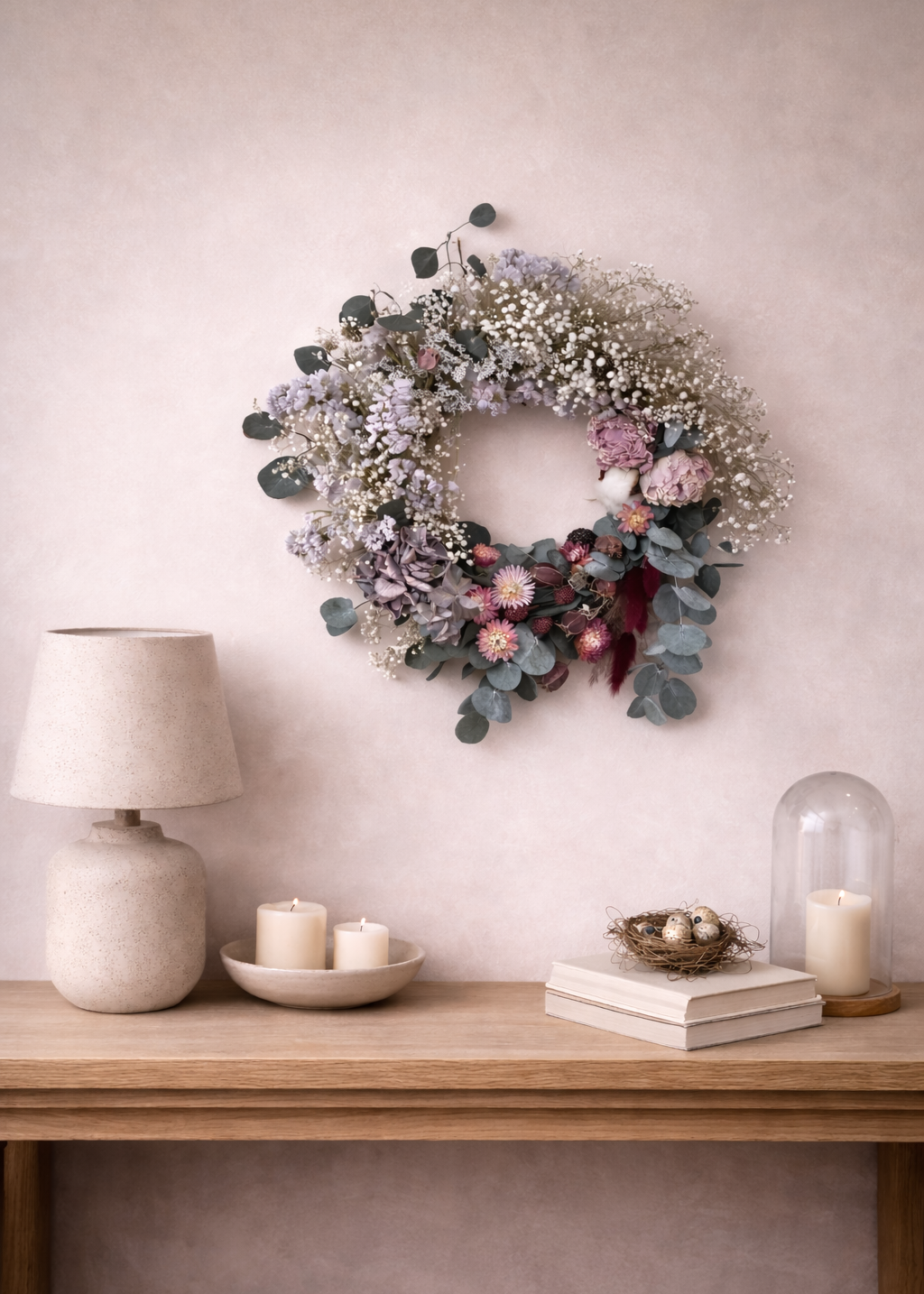 Floral wreath on a wall above a wooden console table with decor items.