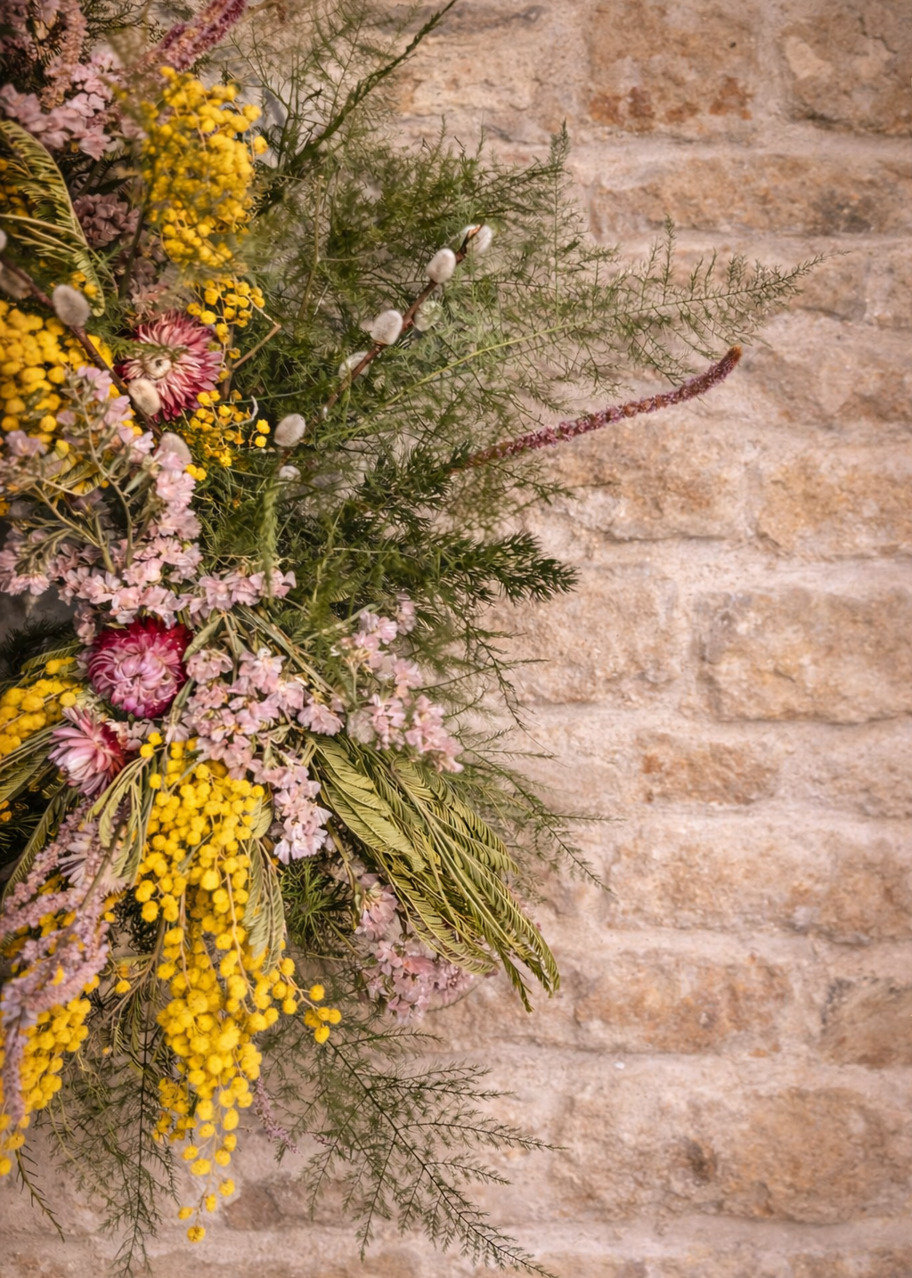 Floral arrangement against a stone wall