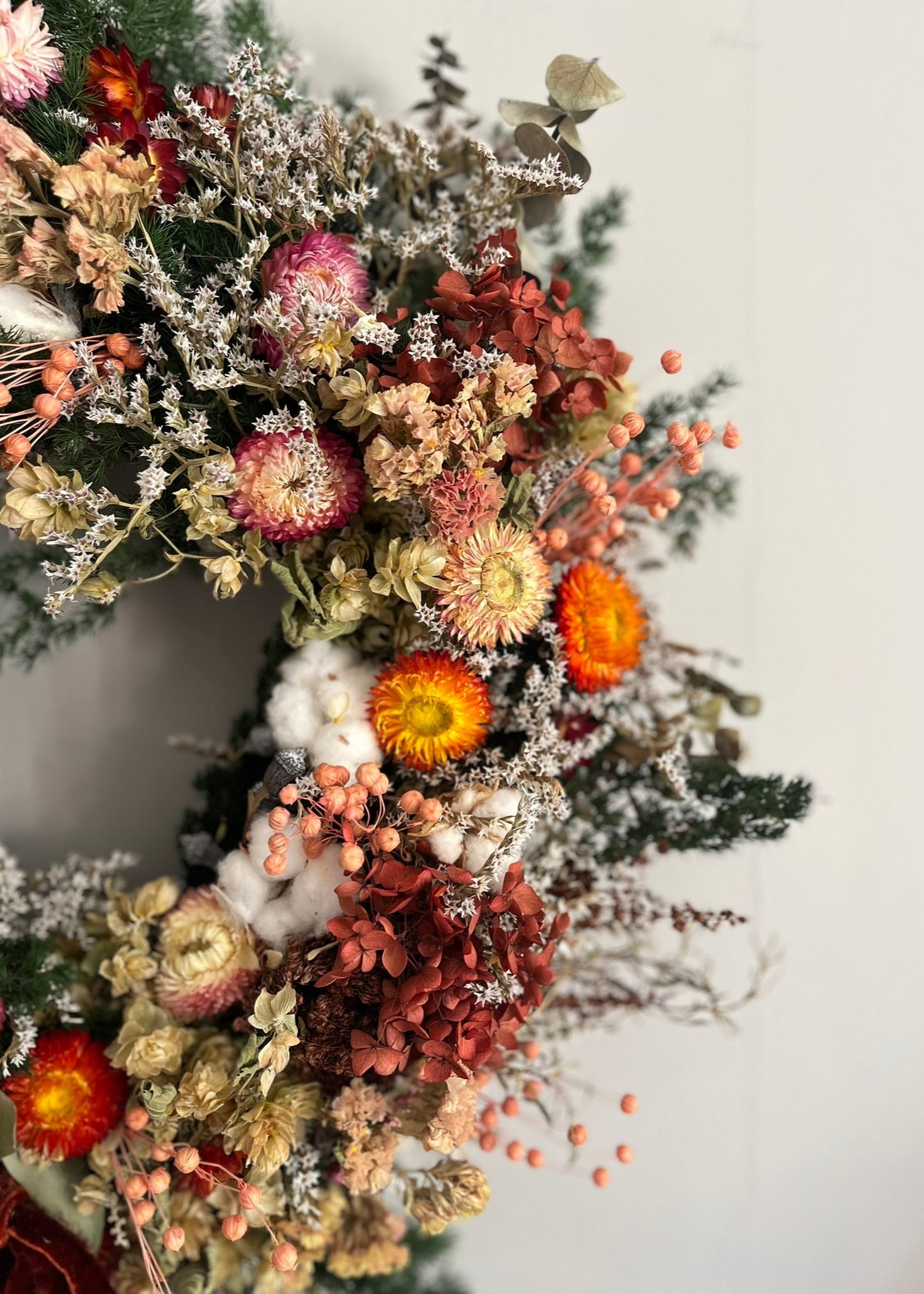 Peach dried flower wreath with terracotta hydrangea, peach berries, helichrysum, green hops, white statice, large wild natural wreath withscented eucalyptus with a hand torn rustic burnt orange ribbon bow at the bottom centre of grapevine base.