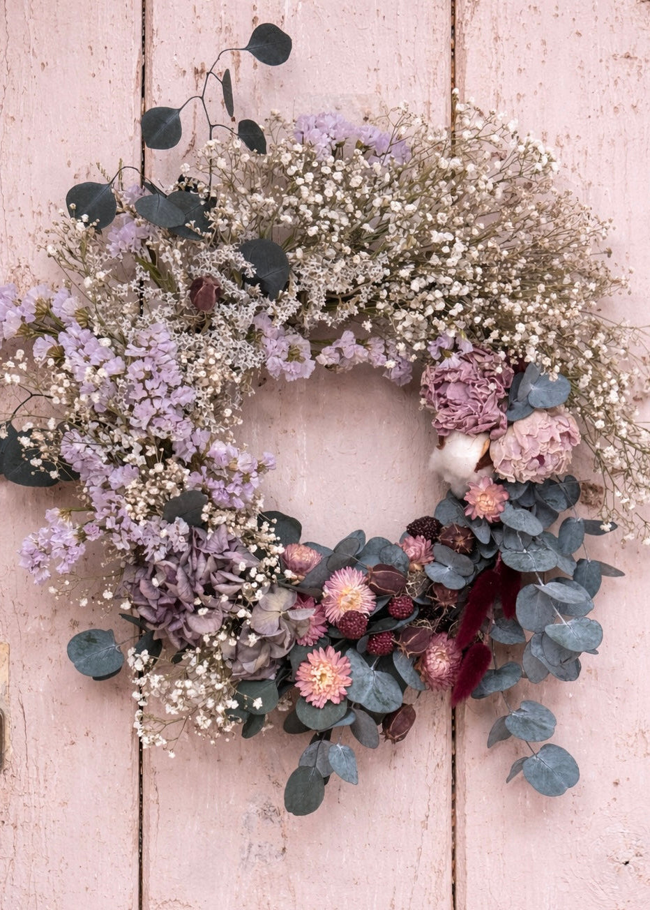 Floral wreath with various flowers on a wooden door