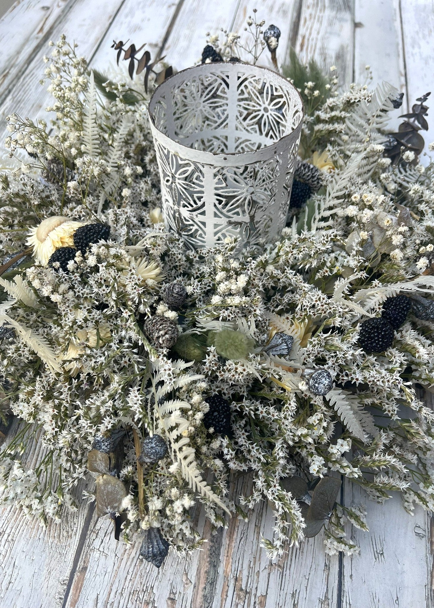 Decorative wreath with a candle holder on a wooden surface