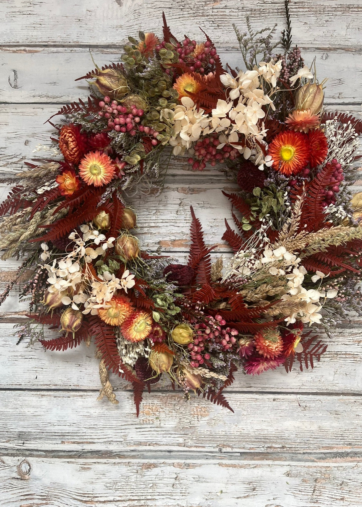 Autumn-themed floral wreath on a wooden background