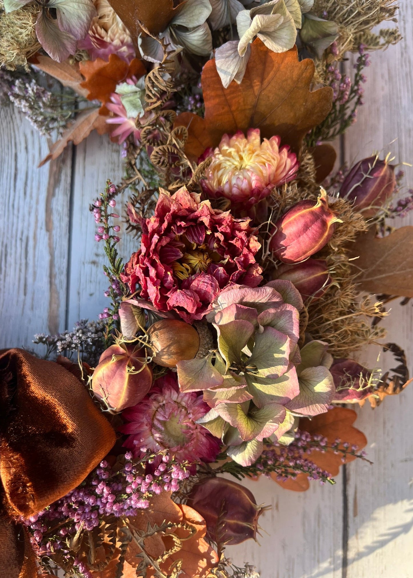 Dried floral arrangement with autumn colors on a wooden surface