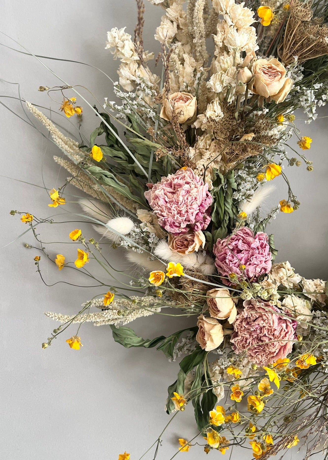 Bouquet of dried flowers with pink and white flowers on a light gray background