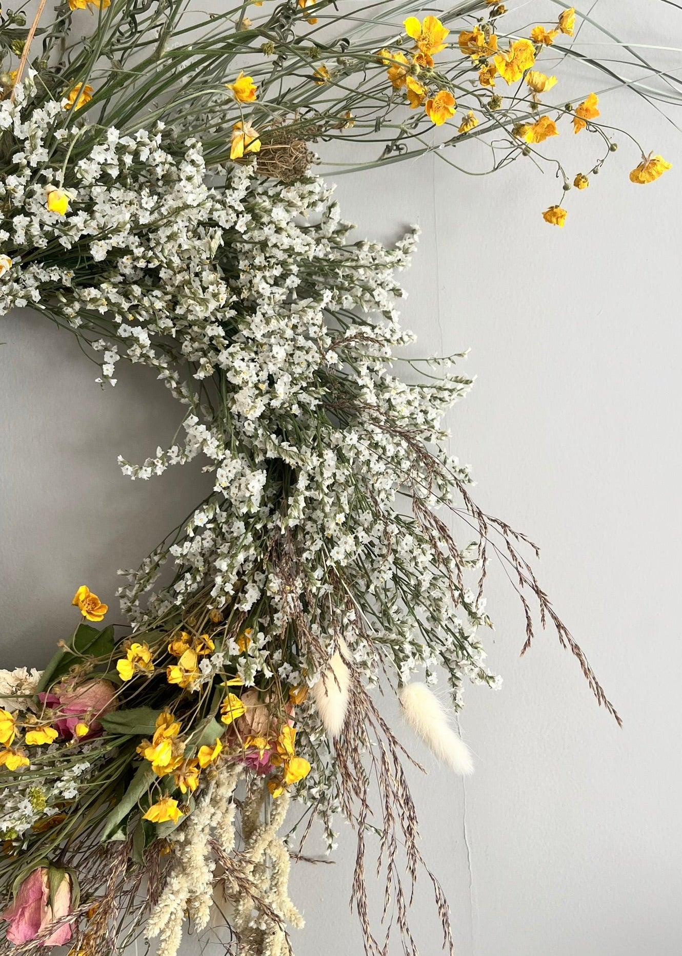 Dried flowers and buttercups on a gray background
