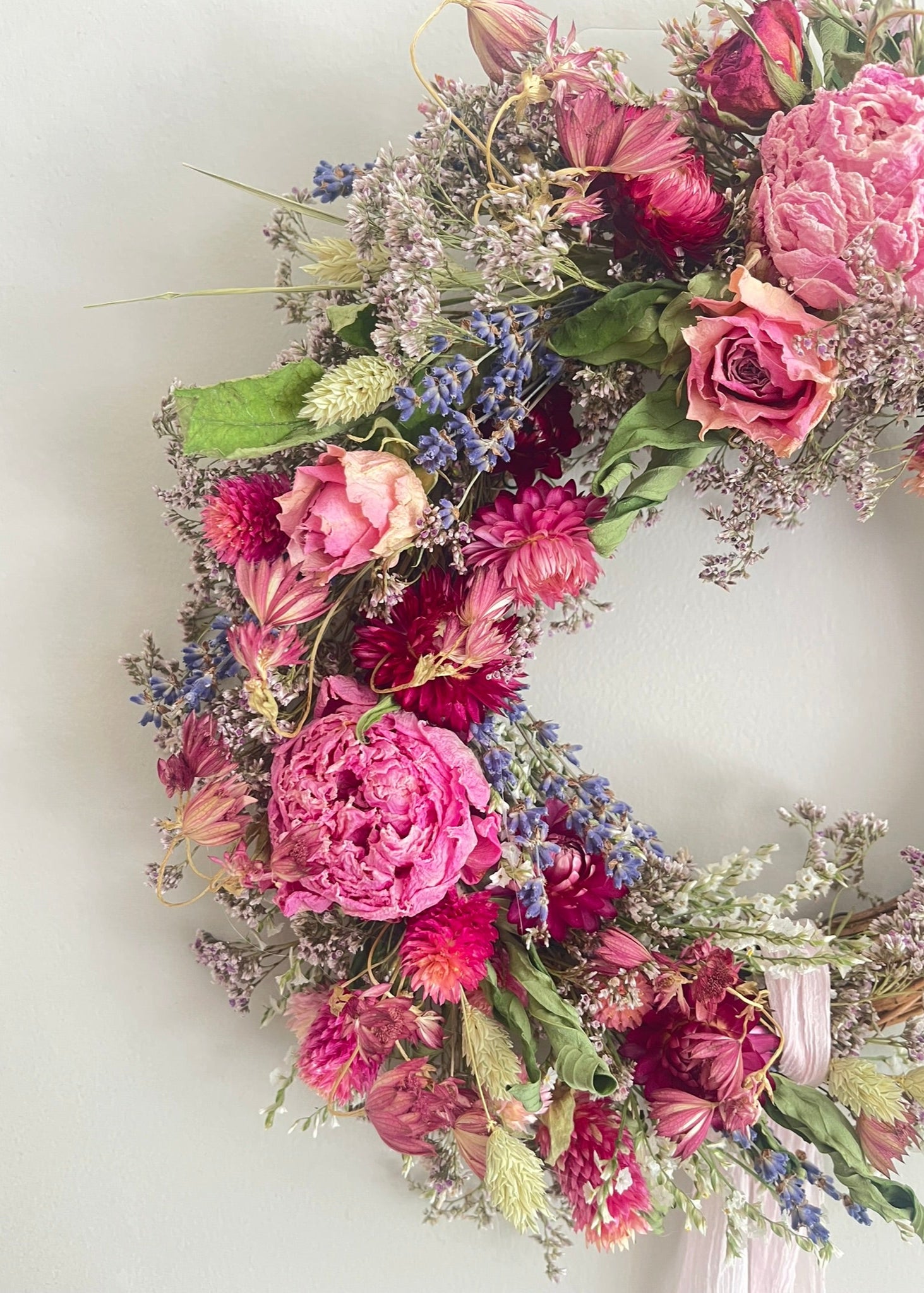 Floral wreath with pink and purple flowers on a white background