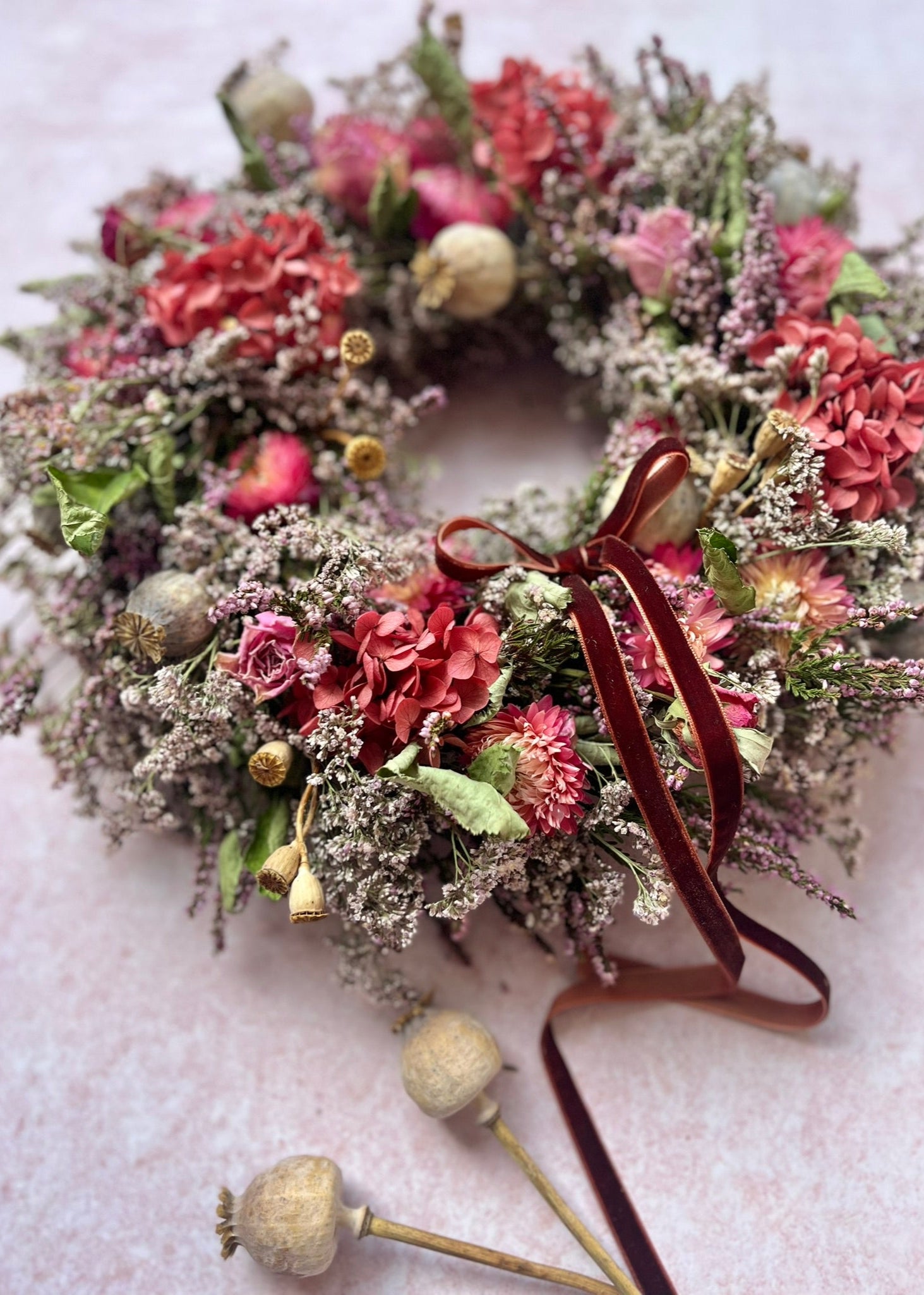Floral wreath with red ribbon on a light background