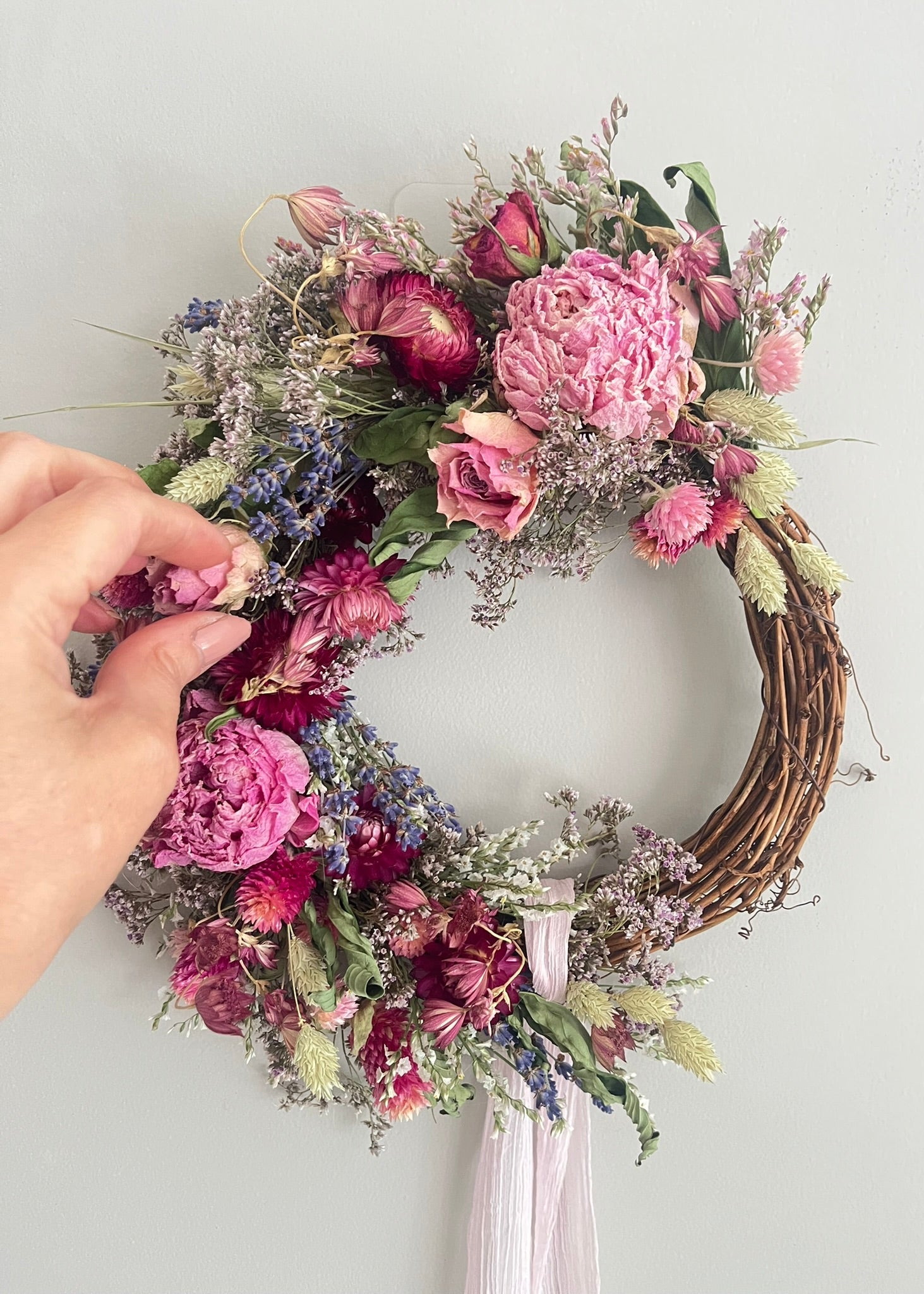 Floral wreath with pink and purple flowers on a plain background