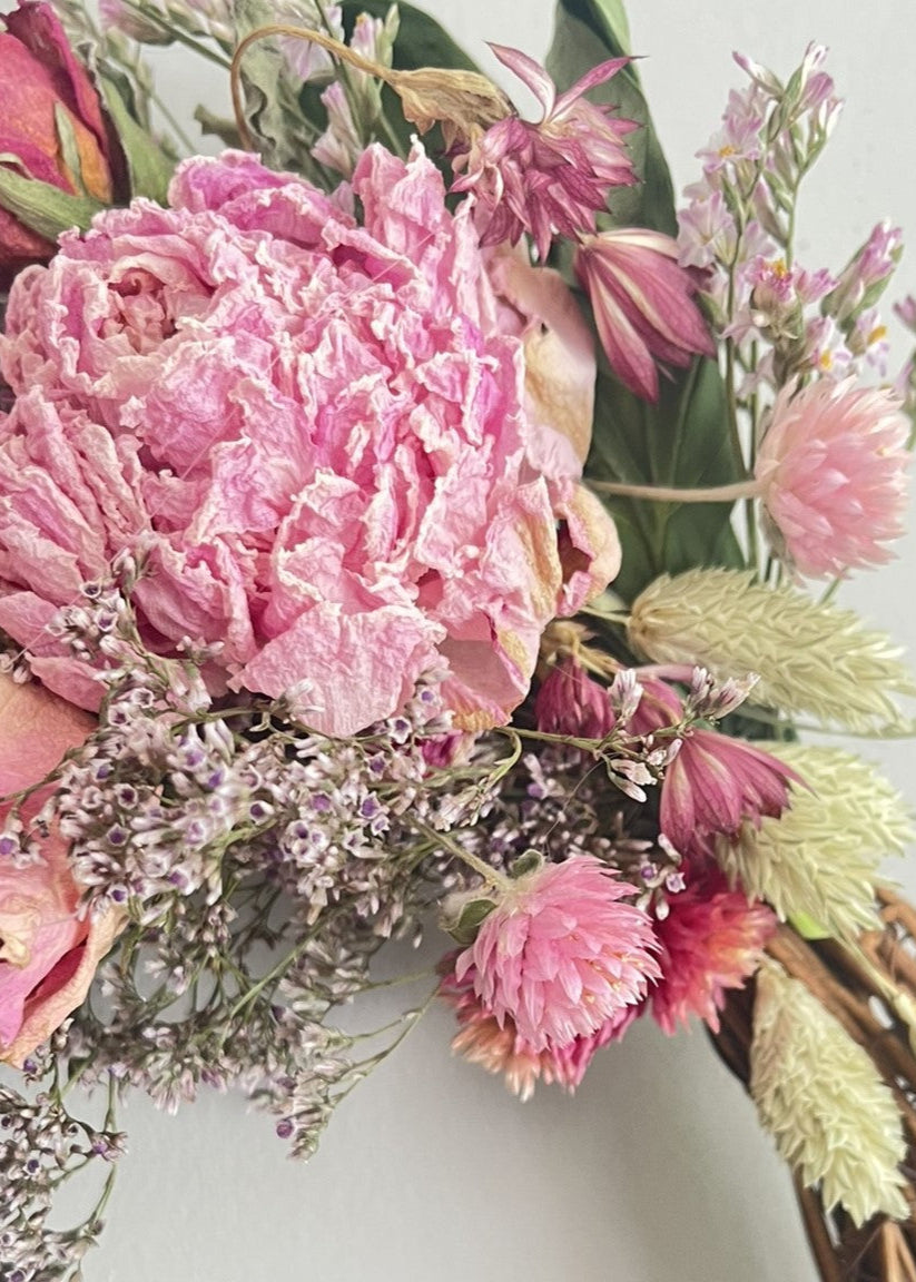 Bouquet of pink and red flowers with green leaves on a light gray background